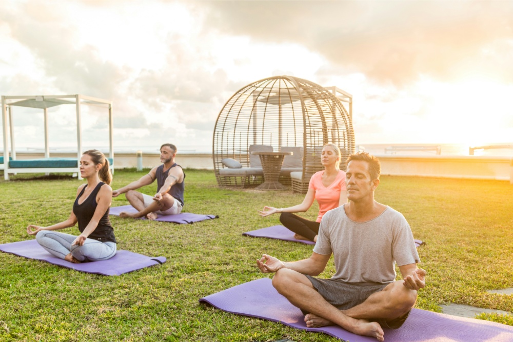 Mujer haciendo yoga en la playa